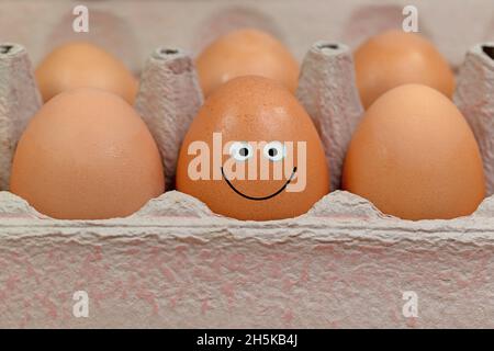Eggs in the packaging with a funny face Stock Photo