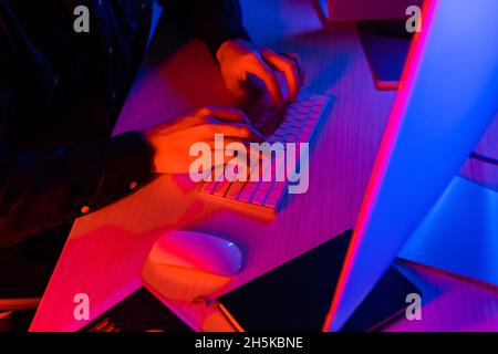 Cropped view of programmer using computer near notebook on table Stock Photo