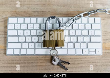 Top view of padlock and keys on keyboard on table Stock Photo