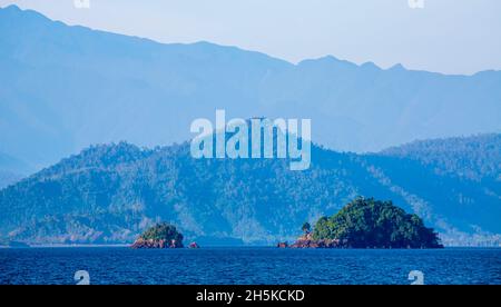 Vista of rainforest covered coast, hills and islands from the Solomon Sea off the shore of Morobe Province, Papua New Guinea Stock Photo