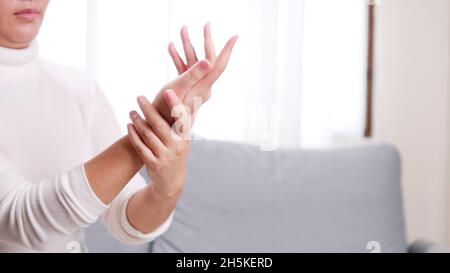 Detail of young woman performing moisturizing hand. Stock Photo
