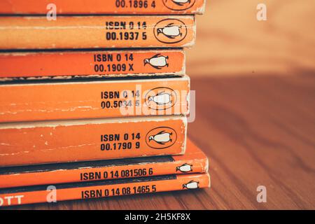 MADRID, SPAIN - Nov 09, 2021: Collection of old Penguin books on wooden shelf. Vintage penguin books at a bookstore. Stock Photo