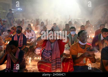 NOVMBER 06,2021,DHAKA,BANGLADESH-Thousands of Hindu devotees sit with Prodip and pray to God in front of Shri Shri Lokanath Brahmachari Ashram temple Stock Photo