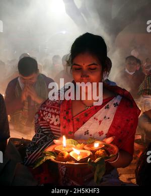 NOVMBER 06,2021,DHAKA,BANGLADESH-Thousands of Hindu devotees sit with Prodip and pray to God in front of Shri Shri Lokanath Brahmachari Ashram temple Stock Photo