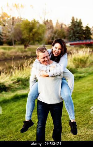 Portrait of a mid adult couple having fun in a park in autumn; St. Albert, Alberta, Canada Stock Photo