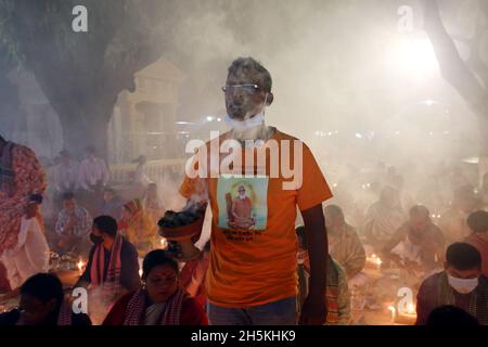 NOVMBER 06,2021,DHAKA,BANGLADESH-Thousands of Hindu devotees sit with Prodip and pray to God in front of Shri Shri Lokanath Brahmachari Ashram temple Stock Photo