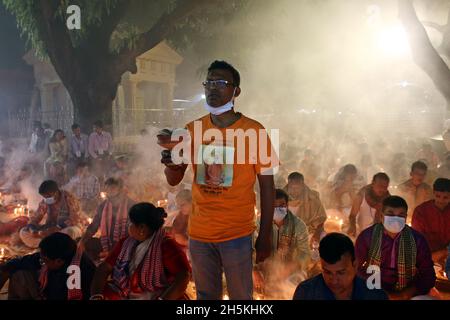 NOVMBER 06,2021,DHAKA,BANGLADESH-Thousands of Hindu devotees sit with Prodip and pray to God in front of Shri Shri Lokanath Brahmachari Ashram temple Stock Photo