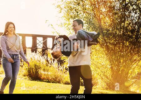 Young family playing football together in a park in autumn; St. Albert, Alberta, Canada Stock Photo