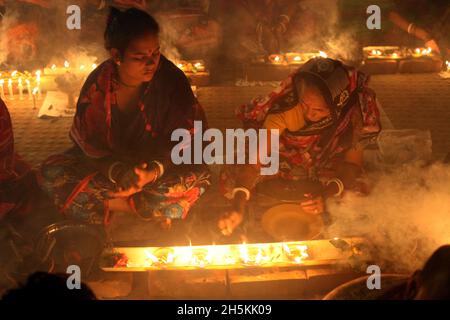 NOVMBER 06,2021,DHAKA,BANGLADESH-Thousands of Hindu devotees sit with Prodip and pray to God in front of Shri Shri Lokanath Brahmachari Ashram temple Stock Photo