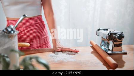 A woman is putting plain flour on a table Stock Photo