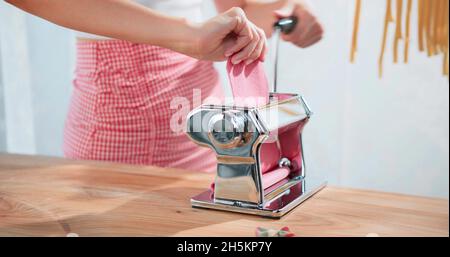 A woman is working pasta with pasta maker Stock Photo