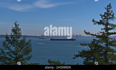 Beautiful view over Burrard Inlet with the skyline of Vancouver, British Columbia, Canada below Mount Rainer and cargo vessels in the bay. Stock Photo