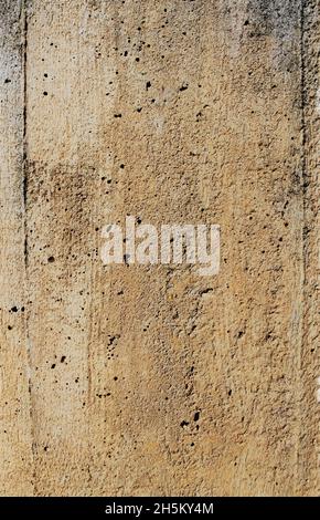 Old gray brown irregular concrete wall as background Stock Photo