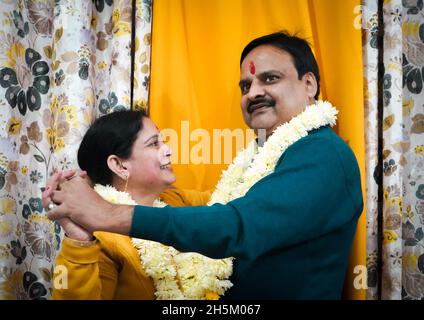 East Asian middle-aged couple with ornaments on their necks dancing and looking at each other Stock Photo