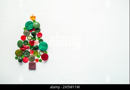 A Christmas tree made of buttons of green, red color. white background, copy space. Creative Christmas Concept. Stock Photo