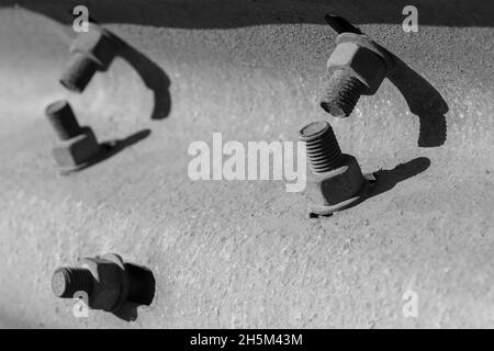 Abstract industrial background with gray bolts and shadows, close-up black and white photo Stock Photo