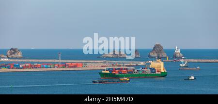 Busan, South Korea - March 22, 2018: Cargo ships are go on Busan bay on a sunny day Stock Photo
