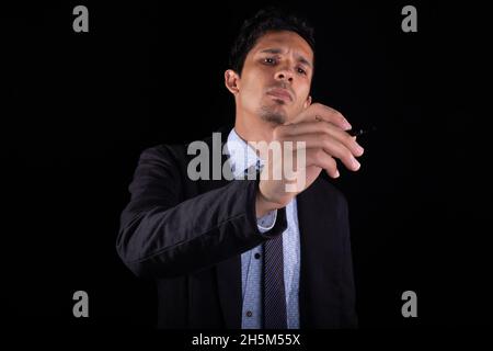Businessman writing in the air. Young businessman drawing, pointing or writing in the air. Stock Photo