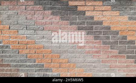 The wall on the street is made of ceramic tiles of different colors, laid out in oblique rows. The wall covers the entire area of the frame