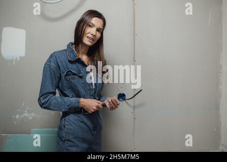 young woman electrician. A young woman herself makes repairs in her apartment Stock Photo