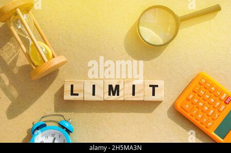Wooden blocks with the word Limit, hourglass, magnifying glass. Risk management in the banking and financial sector. Business and finance concept. Qua Stock Photo