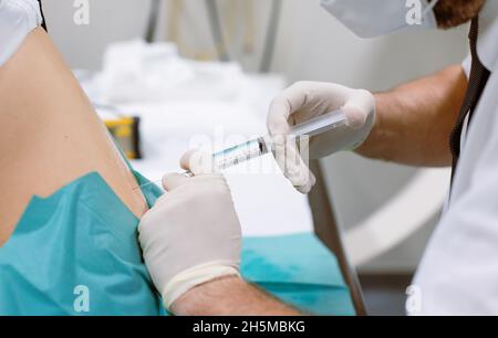 Orthopedic doctor injecting cortisone in slipped disc Stock Photo