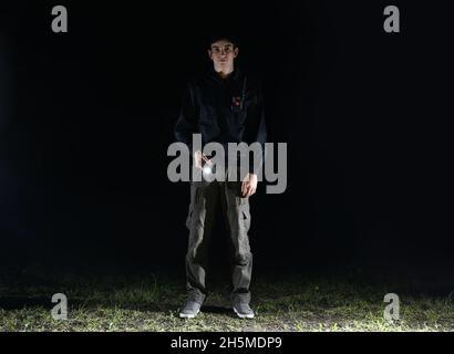 Male security guard with flashlight at night Stock Photo