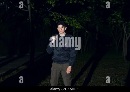 Male security guard with flashlight at night Stock Photo