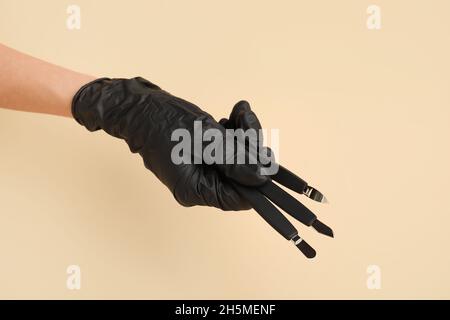 Female hand with manicure equipment on color background Stock Photo