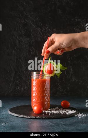 Woman with glass of bloody mary on dark background Stock Photo