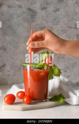 Woman with glass of bloody mary at table Stock Photo