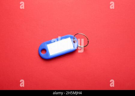 Plastic key tag on red background Stock Photo