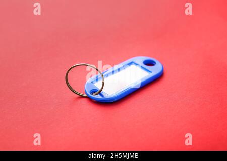 Plastic key tag on red background Stock Photo