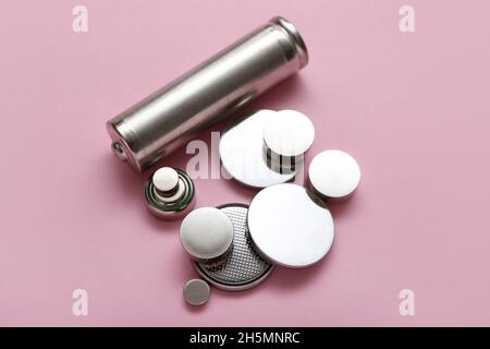 Different batteries on pink background Stock Photo