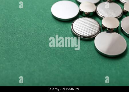Lithium button cell batteries on green background, closeup Stock Photo