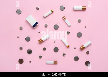 Different batteries on pink background Stock Photo