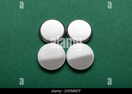 Lithium button cell batteries on green background Stock Photo