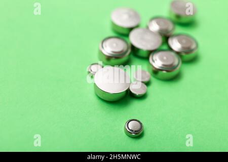 Lithium button cell batteries on green background, closeup Stock Photo