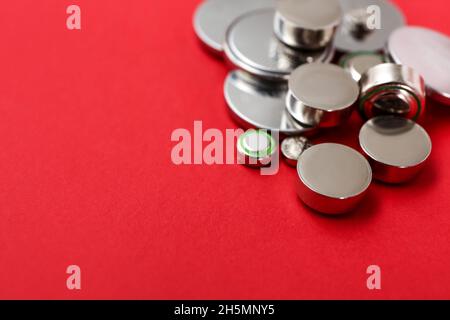 Lithium button cell batteries on red background, closeup Stock Photo