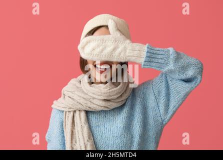 Happy young woman in stylish winter clothes on color background Stock Photo