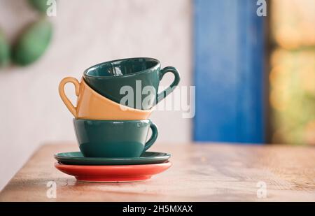stack of coffee cups on wooden table, Focus on the yellow cup Stock Photo