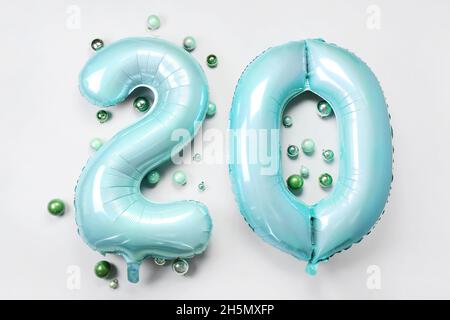 Figure 20 made of balloons and Christmas balls on light background Stock Photo