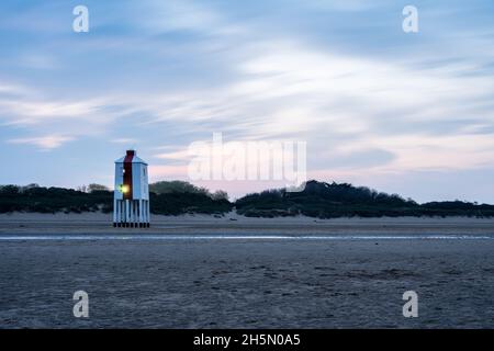 The wooden beach lighthouse is lit in the pre-dawn twilight at Burnham-on-Sea, Somerset. Stock Photo