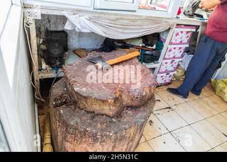 Sarvoda, Sughd Province, Tajikistan. August 16, 2021. Hatchet on a butcher block in the market in Sarvoda. Stock Photo