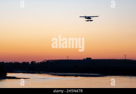 Seaplane flies over the Po river at sunset., Cremona. Italy Stock Photo