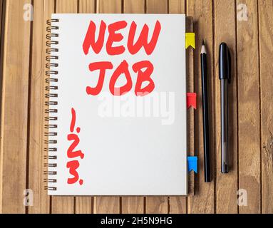 Handwriting text New Job. Business overview recently having paid position of regular employment Blank Open Spiral Notebook With Diffrent Pens Placed Stock Photo