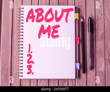 Text sign showing About Me. Concept meaning telling someone list of your good and bad properties Blank Open Spiral Notebook With Diffrent Pens Placed Stock Photo