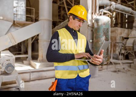 Male engineer working on laptop at factory Stock Photo
