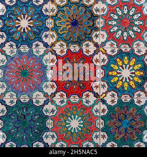 New glazed ceramic tiles, embossed colorful Azulejos, on building wall in Portugal. Traditional ornate Portuguese architecture. Abstract background. Stock Photo