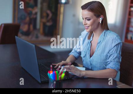 Young fresh positive customer care worker with hands free device at home office Stock Photo